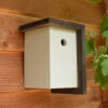 Stabiles Vogelhaus aus Holz mit Dach an der Seite.