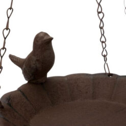 Gietijzeren vogeltje op de rand van een voederschaal voor vogels.