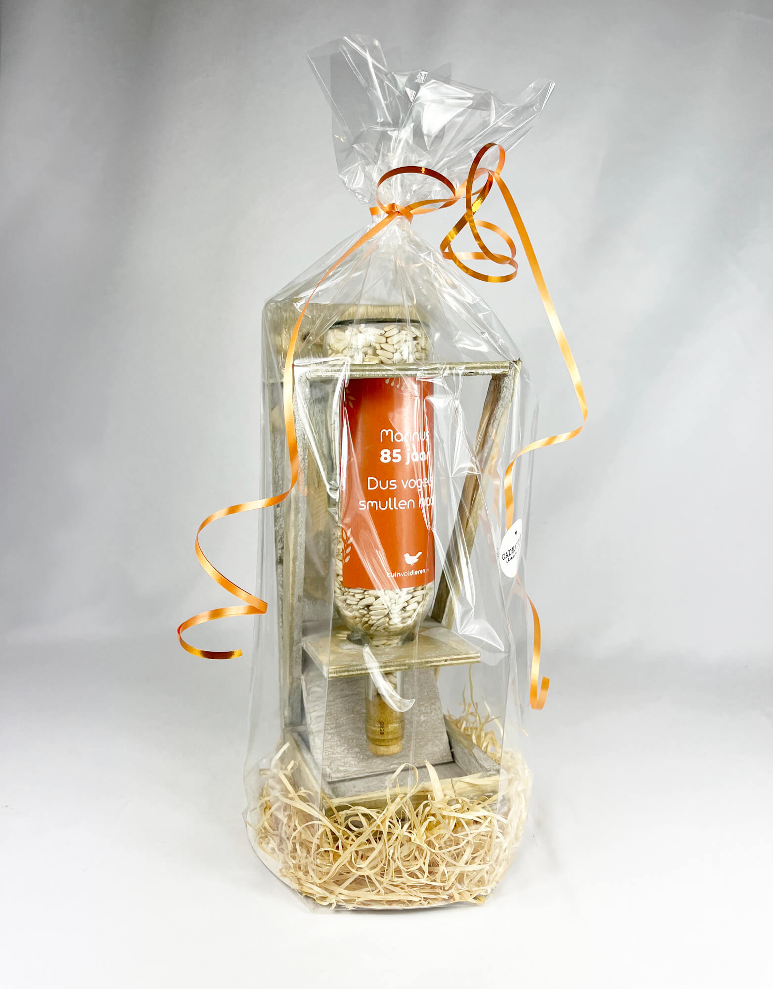 Weinflasche mit eigenem Text zum Geburtstag gefüllt mit Vogelfutter als Geschenk verpackt.